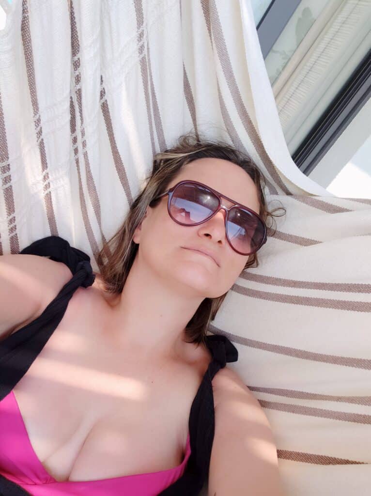 Woman in sunglasses lying on a hammock in Crete, Greece